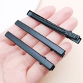 Matte black metal duckbill hair clips with KOREA engraving held in hand for scale - Small / Black