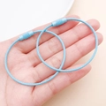 Close-up of sky blue coated wire keychains with non-slip screw connectors in hand - Light Blue