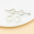 Macro detail of 10mm light green heart glass beads on a white plate for DIY jewelry - Transparent Yellow (26929)
