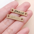 Antique bronze peace connector charm held in hand to show size for DIY jewelry - PEACE Letters (3687) / Antique Bronze