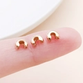 Close-up of 3-4mm rose gold C-shaped crimp covers on fingertips for jewelry making - Medium KC Gold (25588)