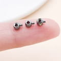 Gunmetal copper round crimp beads for jewelry making shown on a fingertip - Flat Gun Black (25902)