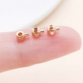 Three rose gold crimp bead endings for DIY jewelry making on a fingertip - Flat KC Gold (25903)