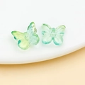 Macro view of gradient glass butterfly beads with translucent texture for DIY jewelry - Transparent Blue Green Gradient