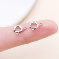 Silver metal spring ring clasp for jewelry DIY shown on fingertip for scale - 6mm / White K (21114)