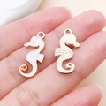Détail de pendentifs hippocampe en émail blanc et finition dorée pour bijoux - Hippocampe de l'Océan (9951)