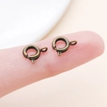 Pair of antique bronze spring ring clasps for jewelry making, shown on a fingertip - Antique Bronze (25912)