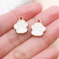 Gros plan de pendentifs pattes de chat dorés en émail blanc avec anneaux de fixation - Patte de Chat Patte d'Ours (23312)