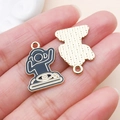 Vue macro de pendentifs émaillés noirs montrant le devant doré et le dos texturé en métal - Mixeur DJ (23809)