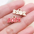 Makroaufnahme der 2028 Jahr-Anhänger in roter Emaille und Gold-Finish auf der Handfläche - 1 Stück / Rot (2028)
