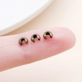 Antique bronze metal crimp beads for jewelry making shown in small size on a finger - Small Antique Bronze (25586)