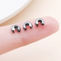 Gunmetal C-shaped metal crimp bead covers shown on a fingertip for size reference - Medium Gun Black (25594)