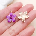 Purple enamel and gold floral charms with pendant hooks shown on finger for size scale - Cherry Blossom Style (10959)