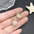 Pink pearl-tone shell charm with gold-finish back held by hand for scale and detail - Enamel White-Pink Shell (8607)