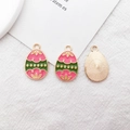 Detail of three Easter egg charms with pink and green enamel petals and gold plating - Pink and Green Egg