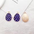 Detail of blue enamel Easter egg pendant with dots and golden sunburst back - Red Polka Dot Egg