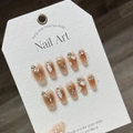 Handgemaakte kunstnagels met karamel ombre, gouden hartjes en strass accenten - Extra Klein (XS) / 944 Crème Hart Korte Trapezium Stijl