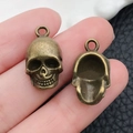 Detail of vintage bronze skull pendants showing intricate front carving and hollow back design - Halloween Skeleton (205) / 12x20