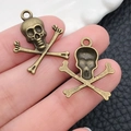 Macro view of bronze skull and crossbones metal charms for DIY jewelry crafting - Halloween Small Skeleton (5373) / 20x23