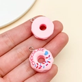 Detail showing front and back of pink resin donut charm with chocolate text and heart patterns - Pink (23858)