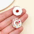 Macro view of 3D resin donut pendants with chocolate text and colorful sprinkles - White (23857)