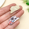 Hand holding vintage alloy hat pendants with colorful oil-drip floral pattern and gold back - Gold Purple White Print Cowboy Hat (23762)