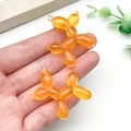Dettaglio di ciondoli a forma di cane palloncino in resina arancione per creazioni fai-da-te - Stile Cane Palloncino Arancione Luccicante (23905)