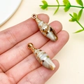 Detail of acrylic laser-plated sea shell charms with gold stripes held in hand - Laser Plated Gold Beige Ocean Conch (23621)