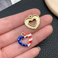 Hand holding heart-shaped American flag pendant and gold striped alloy charm - KC Gold Blue White Red Enamel Alloy USA Flag Star Heart