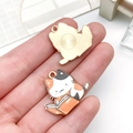 Detailansicht von Vorder- und Rückseite der Metallanhänger mit lesender Katze Motiv - Gelb (23560)