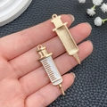 Detail of syringe-shaped metal charms with white enamel and golden embossed finish - Large White Syringe (23229)