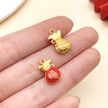 Dettaglio macro del ciondolo borsa Fu smaltata rossa e monete d'oro nella mano - Borsa di Monete di Rame Smaltata Rossa Oro Antico (22797)