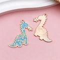 Detail van de hemelsblauwe emaille dinosaurus hanger met bloemmotieven en gouden metalen rug - Blauwe Cartoon Dinosauriër (18105)