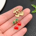 Detailed close-up of cherry alloy charms for DIY jewelry making on leather surface - KC Gold Red Enamel Heart Fruit Cherry (23443) / 20x17x2mm