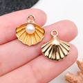 Vue macro de pendentifs coquillage en alliage doré avec émail orange et perles blanches - Orange Jaune Émail Coquillage Marin (15777)
