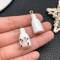 Close-up of DIY resin miniature milk bottle charms held in hand for jewelry making - White 3D Cow Milk Bottle (23952)