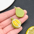 Detail of realistic resin durian pendants in hand showing scale and vibrant colors - Durian