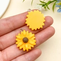 Detail of sunflower resin charm showing yellow petals and a brown core with metal ring - Yellow (24597)