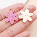 Macro view of pink enamel snowflake pendants with golden alloy frames for DIY jewelry crafts - Pink Christmas Snowflake Style (24816)