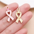 Vista macro di ciondoli a nastro rosa smaltato con cuore e retro dorato ruvido - Ciondolo Nastro con Fiocco e Cuore Rosa (24877)