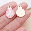 Macro shot of pink snowflake charms on fingertips showing small size for DIY jewelry - Pink Christmas Round Snowflake (25467)