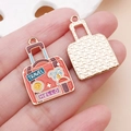 Vue macro de breloques valise de voyage en émail rose pour la création DIY - Modèle Bagages Orange