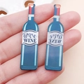 Handgehaltene Ansicht der doppelseitigen blauen Acryl-Weinflaschenanhänger für DIY-Schmuck - Blaue Acryl Doppelseitige Weinflasche (24665)