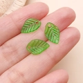 Vista macro de tres colgantes de hoja de acrílico verde traslúcido para joyería DIY - Hoja Pequeña (22157)