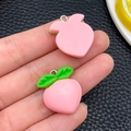 Dettaglio di ciondoli a forma di pesca in resina rosa con foglie verdi e ganci per DIY - Pesca Rosa Media (24240)
