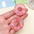 Detail van roze hars donut hangers met glitters en zeedierpatronen voor DIY-sieraden - Transparant roze