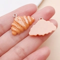 Macro shot of 3D resin croissant charms showing realistic bread texture and silver rings - Croissant (24638)