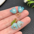 Detailopname van hemelblauwe lelietje-van-dalen hangers van hars met gouden accenten DIY - Transparant Blauw (23267)