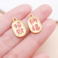 Close-up of gold-plated oval pendants with red enamel Zhaocai and Nafu characters - Large Fortune and Blessing (Ancient Gold)