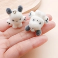 Macro shot of two white flocked puppy charms with black ears and metal rings - 26x25x22mm / Black White Resin Flocked Paw Puppy (24798)